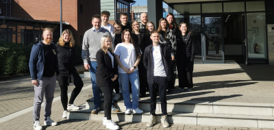 Personengruppe vor einem Backsteingebäude