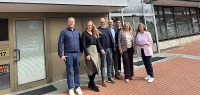 Gruppe von Personen vor Haus stehend