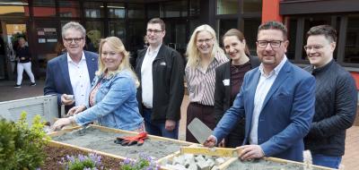 Sieben Personen stehen vor einem Gebäude.