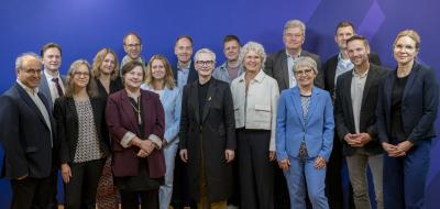 Personengruppe vor einem blauen Hintergrund