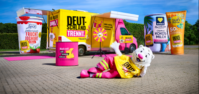 Showtruck auf einem Parkplatz mit überdimensionalen Verpackungen und einem Maskottchen