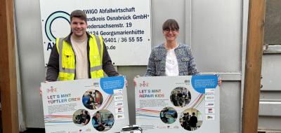 Zwei Personen stehen vor einem Container