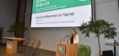 Person an einem Rednerpult auf einer Bühne