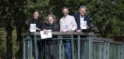 Vier Personen stehen auf einer Brücke.