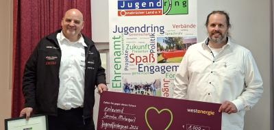 Zwei Personen mit Urkunde und symbolischem Scheck
