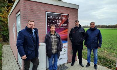 Vier Personen stehen vor einem technischen Gebäude.