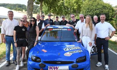 Gruppe von Personen stehend um Sportwagen