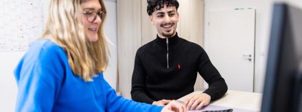 Zwei Personen an einem Stehschreibtisch