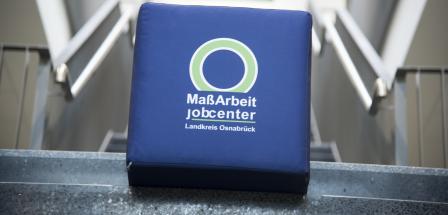 Ein Würfel mit MaßArbeit Logo liegt auf einer Treppe.