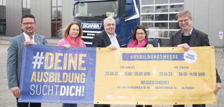 5 Personen vor Plakat