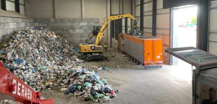 Innenansicht einer Lagerhalle mit Bagger und LKW
