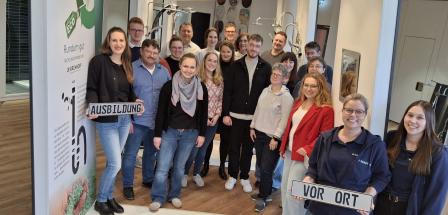 Eine Personengruppe steht im Ausstellungsraum eines Sanitärunternehmens.