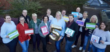 Eine Personengruppe schaut nach oben in die Kamera.