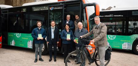 Eine Personengruppe steht vor einem Linienbus.