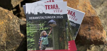 Eine Broschüre steht auf Natursteinen.