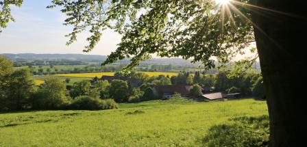 Landschaft mit Haus und Sonne