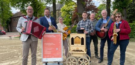 Sieben Personen mit Musikinstrumenten stehen auf einem Hof.