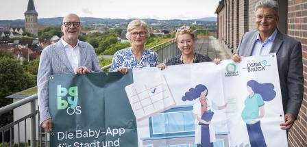 4 Personen mit Plakat im Freien