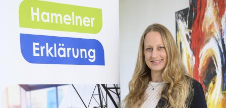 Eine Person steht neben einem Rollup-Poster