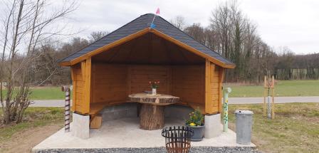 Eine Grillhütte steht in einer Wiesenlandschaft