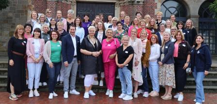 Personengruppe steht vor einer Kirche
