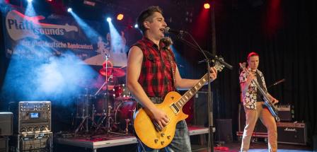 Drei Rockmusiker auf einer Bühne