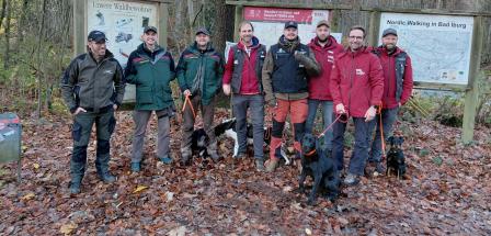 Personengruppe steht auf einer Waldlichtung
