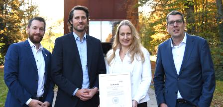 Vier Personen stehen in einem Park.