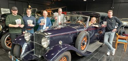 Sechs Personen stehen hinter und vor einem Oldtimer.