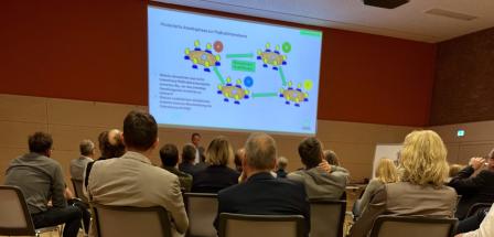 Personengruppe sitzt vor einer Projektionsfläche