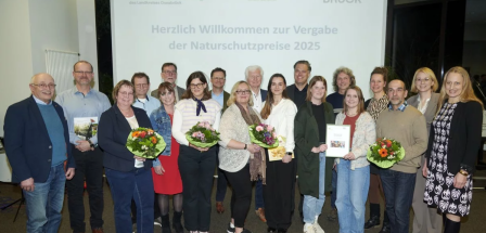 Personengruppe steht vor einer Projektionswand