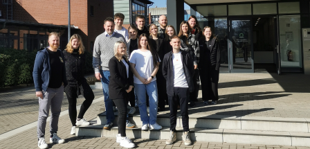 Personengruppe vor einem Backsteingebäude