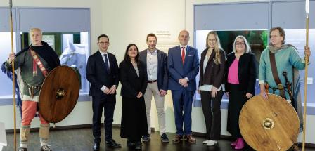 Eine Personengruppe steht in einer Ausstellung