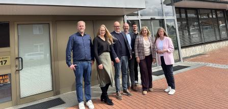 Gruppe von Personen vor Haus stehend