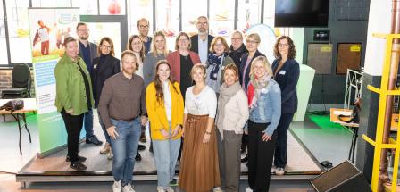 Personengruppe steht auf einer Bühne