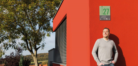 Mann an Hauswand lehnende