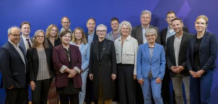 Personengruppe vor einem blauen Hintergrund