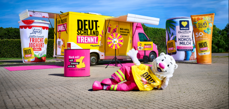 Showtruck auf einem Parkplatz mit überdimensionalen Verpackungen und einem Maskottchen