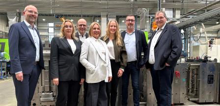 Sieben Personen in einer Werkhalle