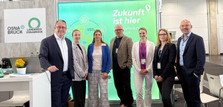 Sieben Personen auf einem Messestand