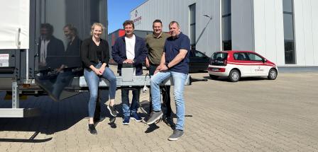Vier Personen vor einer Werkhalle