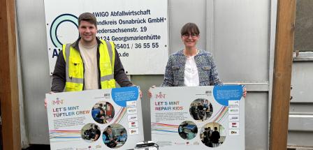 Zwei Personen stehen vor einem Container