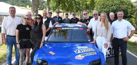 Gruppe von Personen stehend um Sportwagen