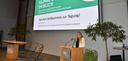 Person an einem Rednerpult auf einer Bühne
