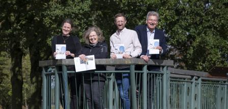 Vier Personen stehen auf einer Brücke.