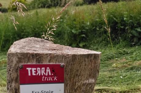 Hüggel, Silberberg Im Vordergrund ein Wegweiser und im Hintergrund eine Wiese am Hang