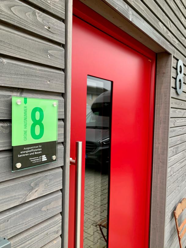 Grüne Hausnummer Bild einer roten Haustür mit grüner Hausnummer