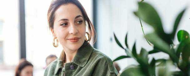 Eine Person neben einer Grünpflanze