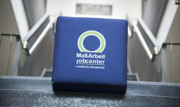 Ein Würfel mit MaßArbeit Logo liegt auf einer Treppe.