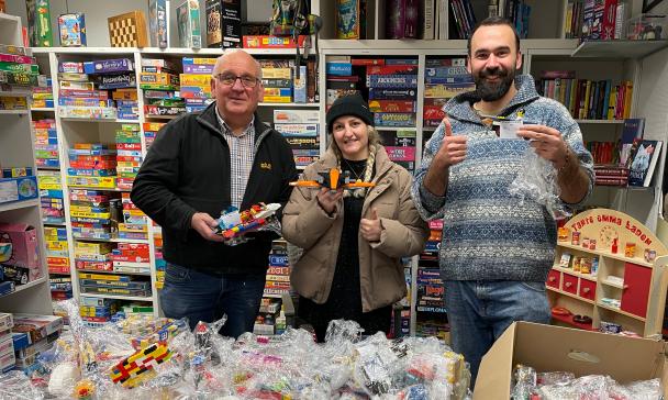 3 Personen vor Lego-Tüten stehend